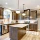 Brightly lit remodeled kitchen with wooden cupboards and island in Green Bay, WI